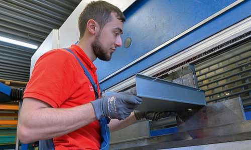 Mitarbeiter kantet ein Bauteil